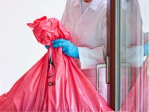 Operatore porta un sacco con rifiuti speciali pericolosi