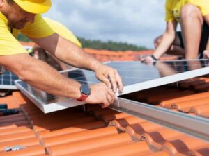 operai durante la rimozione dei pannelli fotovoltaici dal tetto di un edificio