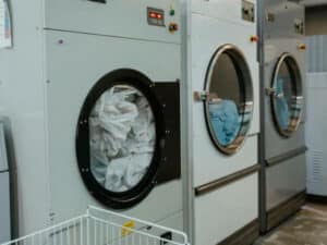 tre lavatrici industriali di grandi dimensioni in uso