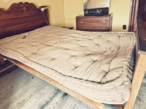 materasso vecchio da buttare sulla struttura in legno in una camera da letto
